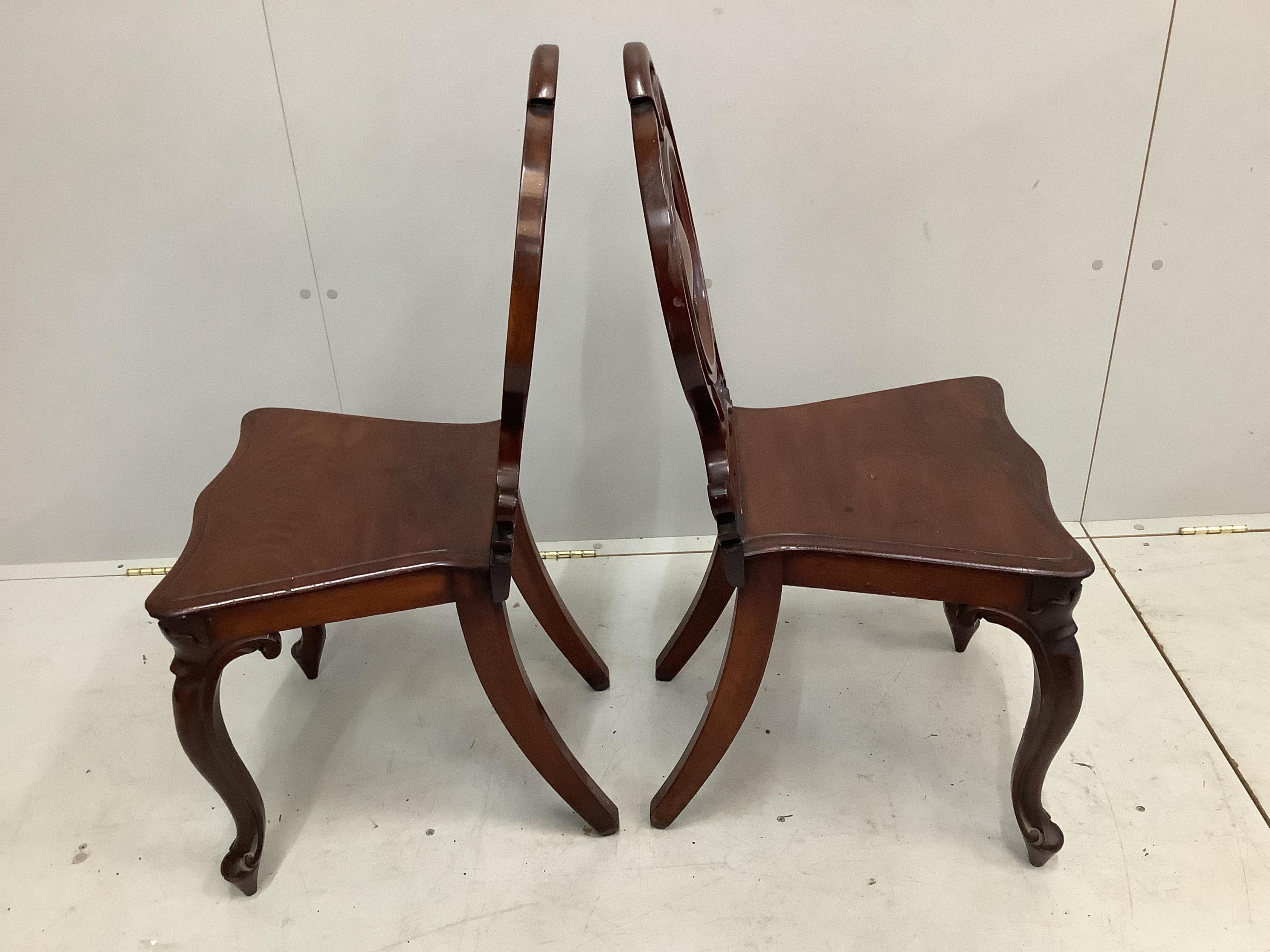 A pair of Victorian mahogany hall chairs, width 43cm, depth 35cm, height 68cm. Condition - fair